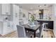 Modern dining area adjacent to a kitchen featuring white cabinets and black accents at 1349 Lockhaven Sw Cir, Atlanta, GA 30311