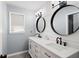 Bathroom featuring double vanity with modern fixtures, shiplap wall, and decorative round mirrors at 220 Mars Hill Rd, Powder Springs, GA 30127