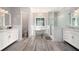 This bathroom is filled with natural light and features a soaking tub, chandelier, and & vanities at 220 Mars Hill Rd, Powder Springs, GA 30127