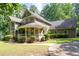 Charming home with a wraparound porch that enhances the appeal of the property, complemented by lush landscaping at 220 Mars Hill Rd, Powder Springs, GA 30127