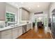 Bright kitchen with white cabinets, tile backsplash, and stainless steel appliances, offering a view into the dining area at 220 Mars Hill Rd, Powder Springs, GA 30127