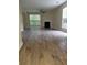 Spacious living room with fireplace, wood-look tile floors, and large windows at 5030 N Bridges Dr, Alpharetta, GA 30022