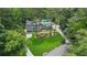 Aerial view of home surrounded by lush greenery with a well-manicured lawn and large, curved driveway at 555 Valley Hall Dr, Atlanta, GA 30350