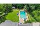 Aerial view of the backyard, featuring a pool, manicured lawn, outbuildings, and mature trees at 555 Valley Hall Dr, Atlanta, GA 30350