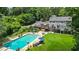 Aerial view of the backyard, featuring a pool, manicured lawn, outbuildings, and mature trees at 555 Valley Hall Dr, Atlanta, GA 30350