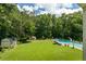 Sprawling backyard featuring pool, manicured lawn, mature trees, and outbuildings at 555 Valley Hall Dr, Atlanta, GA 30350
