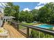 Elevated deck view of a lush backyard, beautiful pool, and quaint outbuildings creates a private oasis at 555 Valley Hall Dr, Atlanta, GA 30350