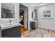 Modern bathroom with dual vanities, LED mirrors, and wood-look floors at 555 Valley Hall Dr, Atlanta, GA 30350