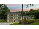 Charming traditional home with a symmetrical facade, lush lawn, and illuminated windows at dusk at 555 Valley Hall Dr, Atlanta, GA 30350