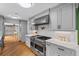 Stylish kitchen featuring gray cabinets, stainless steel appliances, marble countertops, and hardwood floors at 555 Valley Hall Dr, Atlanta, GA 30350