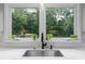 Bright kitchen sink beneath a window offering a view of the green backyard at 555 Valley Hall Dr, Atlanta, GA 30350