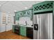 Charming kitchenette with green cabinets, stainless steel appliances, and a unique license plate display at 555 Valley Hall Dr, Atlanta, GA 30350