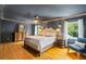 Elegant main bedroom with hardwood floors, paneled accent wall, a ceiling fan, and natural light at 555 Valley Hall Dr, Atlanta, GA 30350