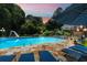 Backyard pool area features lounge seating, stone pool deck, and a slide, surrounded by lush trees at 555 Valley Hall Dr, Atlanta, GA 30350