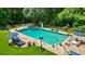 Backyard pool features lounge seating, stone pool deck, slide, and manicured lawn surrounded by trees at 555 Valley Hall Dr, Atlanta, GA 30350