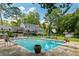 Backyard pool is surrounded by manicured lawn with lush trees, patio space, and screened-in porch at 555 Valley Hall Dr, Atlanta, GA 30350
