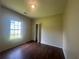 Cozy bedroom featuring wood look floors, closet, and backyard view from a single window at 76 Daisy Meadow Trl, Lawrenceville, GA 30044
