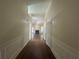 Long hallway featuring wood floors and white paneled walls leading to living room at 76 Daisy Meadow Trl, Lawrenceville, GA 30044