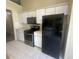 Clean kitchen with white cabinets, stainless steel oven, black appliances, and tile flooring at 76 Daisy Meadow Trl, Lawrenceville, GA 30044