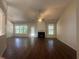 Spacious living room with fireplace, ceiling fan, hardwood floors, and large windows at 76 Daisy Meadow Trl, Lawrenceville, GA 30044