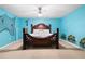 Bright bedroom with light blue walls, detailed headboard, and ceiling fan at 1227 Castle Point Sw Ct, Conyers, GA 30094