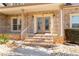 Close up of a home's brick front porch with ornate glass doors, landscaping and a welcoming entrance at 1227 Castle Point Sw Ct, Conyers, GA 30094