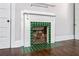 Close-up of the fireplace with decorative green tile surround and hardwood floors at 240 Melrose Ave, Decatur, GA 30030