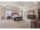 Large main bedroom featuring a decorative tray ceiling, gray furniture and a comfortable sitting area at 2629 Muskeg Sw Ct, Atlanta, GA 30331