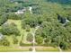 Aerial view of a sprawling wooded property featuring a pool, home, and long driveway at 7234 Post Rd, Winston, GA 30187