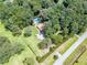Aerial view showcasing wooded property with pool, red roof home, and lush landscaping at 7234 Post Rd, Winston, GA 30187