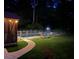 Well-lit backyard at night featuring a pool with a security fence and view of the screened porch at 7234 Post Rd, Winston, GA 30187