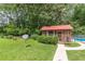 Backyard view with pool, screened porch, satellite, walking path, trees, and green lawn at 7234 Post Rd, Winston, GA 30187