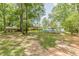 Spacious backyard featuring an in-ground pool, covered parking, and lush landscaping at 7234 Post Rd, Winston, GA 30187