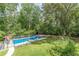 Backyard view featuring a pool with lounge chairs, well-manicured lawn, and lush trees at 7234 Post Rd, Winston, GA 30187