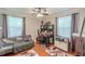 This bedroom features hardwood floors, a ceiling fan, and a desk area with lots of natural light at 7234 Post Rd, Winston, GA 30187