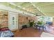 The covered patio has ceiling fans, a brick wall, dining furniture and door to the home at 7234 Post Rd, Winston, GA 30187