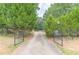View of driveway and gated entrance of the residence flanked by mature landscaping at 7234 Post Rd, Winston, GA 30187
