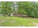 Charming two-story home with brick facade, red shutters, and a spacious, tree-filled front yard at 7234 Post Rd, Winston, GA 30187