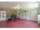 Bright garage with a large door, shelving, red flooring, and storage space for all your organizational needs at 7234 Post Rd, Winston, GA 30187