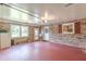 Spacious garage featuring brick walls, windows, a door, and red floors, offering ample space for vehicles and storage at 7234 Post Rd, Winston, GA 30187