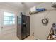 Functional laundry area equipped with a fridge, ample storage, and outdoor access, streamlining household tasks at 7234 Post Rd, Winston, GA 30187