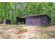 Shed set among mature trees features a fire pit and ample storage space at 7234 Post Rd, Winston, GA 30187