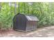 Backyard storage shed surrounded by mature trees offering extra storage space at 7234 Post Rd, Winston, GA 30187