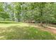 The vast front yard of this home is covered in green grass and shaded by large trees at 7234 Post Rd, Winston, GA 30187