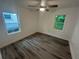 Bedroom with wood-look floors and ceiling fan has two windows for natural light at 876 Pinehurst Sw Ter, Atlanta, GA 30310