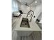 Modern kitchen with stainless sink in an island open to the living room featuring luxury vinyl floors at 876 Pinehurst Sw Ter, Atlanta, GA 30310