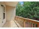 Outdoor balcony with wood railing and flooring overlooking lush green trees at 1986 Cobblestone Ne Cir, Atlanta, GA 30319