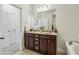 Bathroom featuring double sinks, dark cabinetry, a large mirror, and access to additional rooms at 1986 Cobblestone Ne Cir, Atlanta, GA 30319