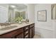 Bathroom featuring double sinks, dark cabinetry, a large mirror, and a soaking tub at 1986 Cobblestone Ne Cir, Atlanta, GA 30319