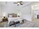 Main bedroom featuring a tray ceiling, a ceiling fan, a bench, and is decorated in neutral colors at 1986 Cobblestone Ne Cir, Atlanta, GA 30319